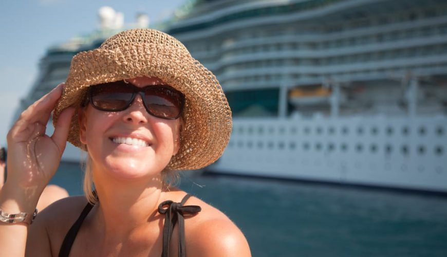 Mujer sonriendo delante de un crucero, en el puerto. Viaje curcero romántico