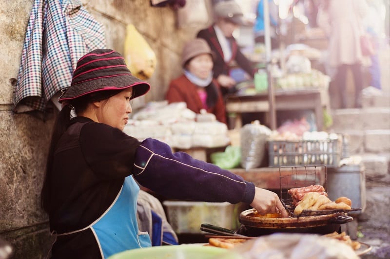 Mujer trabajando en un mercadillo en Vietnam. Viajar a Vietnam.