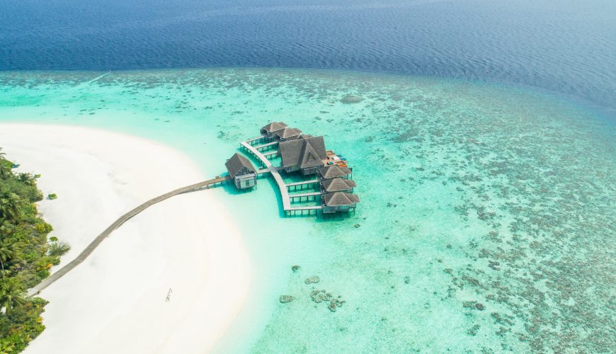 Varias casas, elevadas sobre el mar y conectadas mediante puentes entre ellas. Cosas que saber antes de ir a Maldivas.